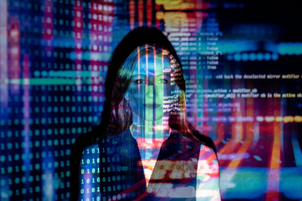 Uma mulher com uma projeção de códigos de programação fazendo mensão a Inteligencia Artificial